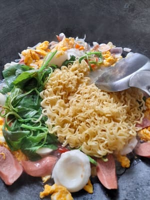 Aggiungere 300 ml di acqua, attendere che l'acqua bolla, aggiungere i pomodori, gli spinaci e le tagliatelle fritte, mescolare bene.