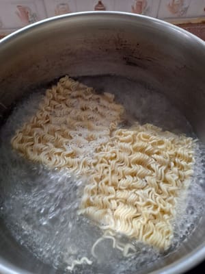 Einen Topf vorbereiten, 600 ml Wasser aufkochen, warten bis das Wasser kocht, die Nudeln hineingeben, die Nudeln halb gar kochen, dann herausnehmen und abtropfen lassen.