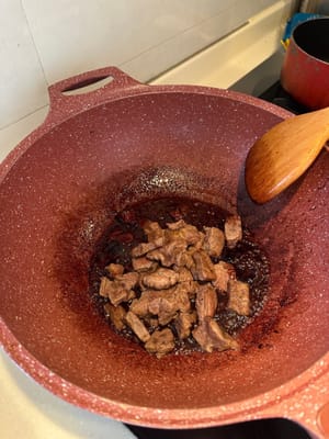 將切丁的牛扒放回鍋中，均勻裹上醬汁。