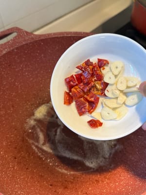 將乾辣椒、大蒜和芫荽煎至棕色。