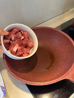 在加熱的平底鍋中倒入橄欖油，將切丁的牛扒煎至略呈褐色，然後盛出備用。