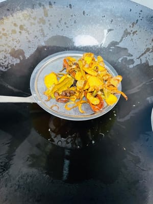 锅里倒入菜籽油，烧至10成热（油完全不冒烟且泡泡消失 ），然后等油温冷却到6成热（先捞几勺出来稍后扮面条用），倒入备好的洋葱片、姜片、葱段、八角、桂皮、香叶，一起翻炒，炒至变黄后捞出渣。