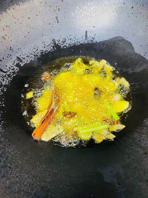 锅里倒入菜籽油，烧至10成热（油完全不冒烟且泡泡消失 ），然后等油温冷却到6成热（先捞几勺出来稍后扮面条用），倒入备好的洋葱片、姜片、葱段、八角、桂皮、香叶，一起翻炒，炒至变黄后捞出渣。
