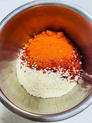 1.準備粗細搭配的辣椒粉，口感會好啲，如果沒，一種也行（專業級是炒香辣椒殼，再打碎）再備啲白芝麻。
2. 待油溫降至6成熱時，將熱油淋入裝有辣椒粉和白芝麻的碗裡，注意油溫不能太高，否則會把辣椒粉燒糊，淋完後攪拌均勻，製成油辣子。