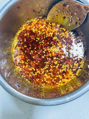 1.準備粗細搭配的辣椒粉，口感會好啲，如果沒，一種也行（專業級是炒香辣椒殼，再打碎）再備啲白芝麻。
2. 待油溫降至6成熱時，將熱油淋入裝有辣椒粉和白芝麻的碗裡，注意油溫不能太高，否則會把辣椒粉燒糊，淋完後攪拌均勻，製成油辣子。