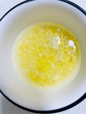 將大蒜和薑切成蓉放碗裡，加入熱開水泡出薑蒜水備用。