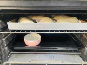 Letakkan adonan roti yang sudah digulung di dalam oven, tambahkan semangkuk air panas, dan biarkan mengembang lagi hingga ukurannya menjadi 1,5 kali ukuran semula. Semprotkan sedikit air di permukaannya dan taburi dengan bubuk keju kering.