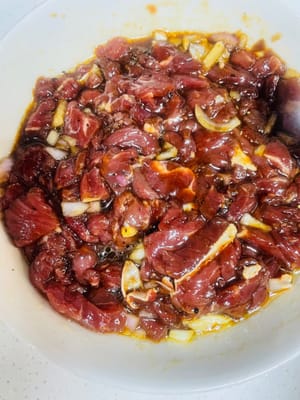 Sambil menunggu adonan mengembang, siapkan isiannya: potong daging sapi menjadi dadu kecil/cincang, tambahkan kecap asin encer, bubuk lada hitam, 1 sendok makan anggur masak, 20 gram saus barbekyu (atau saus lada hitam steak jika tidak ada saus barbekyu), lalu tambahkan bawang bombay yang sudah dipotong dadu dan aduk rata. Diamkan setidaknya selama setengah jam agar daging sapi menyerap bumbu.