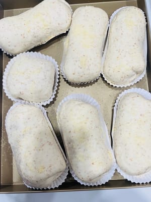 Letakkan adonan roti yang sudah digulung di dalam oven, tambahkan semangkuk air panas, dan biarkan mengembang lagi hingga ukurannya menjadi 1,5 kali ukuran semula. Semprotkan sedikit air di permukaannya dan taburi dengan bubuk keju kering.