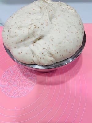 Tutup adonan yang sudah diuleni dengan plastik wrap agar tetap lembap, dan biarkan berfermentasi pada suhu sekitar 30°C hingga ukurannya menjadi dua kali lipat. Adonan siap jika lubang yang ditusuk dengan jari tidak menyusut atau mengempis.