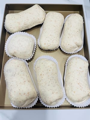 Letakkan adonan roti yang sudah digulung di dalam oven, tambahkan semangkuk air panas, dan biarkan mengembang lagi hingga ukurannya menjadi 1,5 kali ukuran semula. Semprotkan sedikit air di permukaannya dan taburi dengan bubuk keju kering.