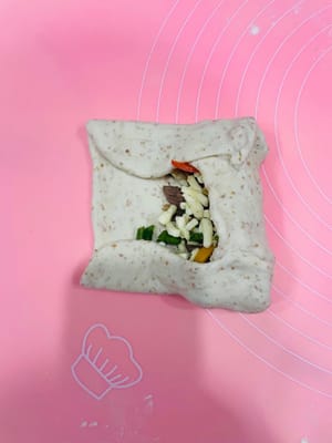 Sebarkan daging sapi giling yang sudah ditiriskan di atasnya, tambahkan keju mozzarella, lalu taburi dengan daun bawang cincang.