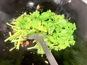 Heat oil in a wok and sauté minced garlic and chopped chili until fragrant. Then add celery and stir-fry until just cooked through.