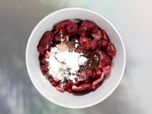 Slice the beef and marinate it with 1 teaspoon oyster sauce, 2 teaspoons light soy sauce, 1/2 teaspoon sugar, 1 teaspoon cooking wine, and 2 teaspoons cornstarch for 20 minutes.