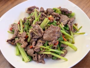Add the stir-fried beef and a teaspoon of oyster sauce, stir-fry over medium-high heat until well combined, and then serve.