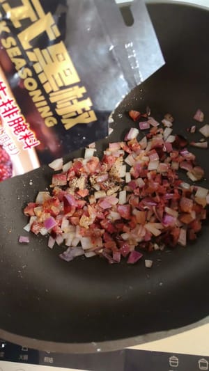 Vaporisez un peu d’huile dans une poêle, ajoutez les oignons coupés en dés et la saucisse, faites revenir à feu moyen jusqu’à ce que le tout soit parfumé, saupoudrez de poivre et d’une pincée de sel, remuez bien pour assaisonner.