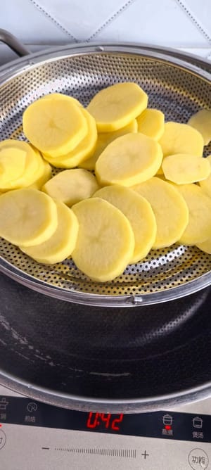 Épluchez les pommes de terre et coupez-les en tranches épaisses. Faites-les cuire à la vapeur pendant 10 minutes après l’ébullition de l’eau.