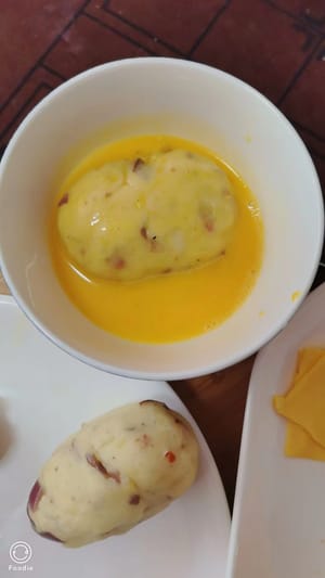 Façonnez des formes de pommes de terre et roulez-les dans un mélange d’œuf battu.