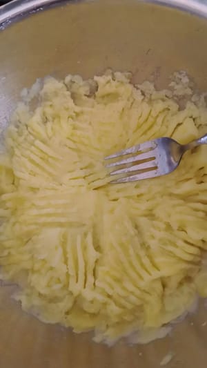 Écrasez les tranches de pommes de terre cuites à la vapeur à la fourchette.