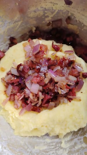 Versez le mélange cuit sur la purée de pommes de terre, ajoutez un peu de sel et mélangez bien en portant des gants.