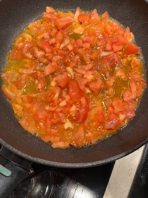 Versez les tomates concassées avec 2 cuillères à café de sucre cristallisé et faites cuire