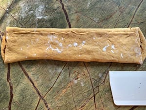 Luego dobla el 1/3 superior de la masa hacia el medio, seguido por el 1/3 inferior.