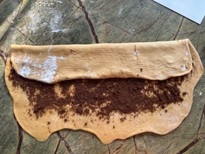 先將麵團上三分之一折到中間，再將下三分之一折到中間。