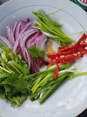 양파를 채 썰고, 붉은 고추를 채 썰고, 샬롯을 조각으로 자르고, 고수를 조각으로 자르고, 마늘 잎을 나중에 사용하기 위해 채 썰습니다.