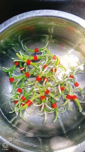 Pour a bottle of clean water into the garlic shoots and soak them for 5 minutes, then take them out and set aside.