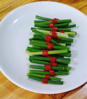 Put the chili peppers on the garlic sprouts and cut them into pieces