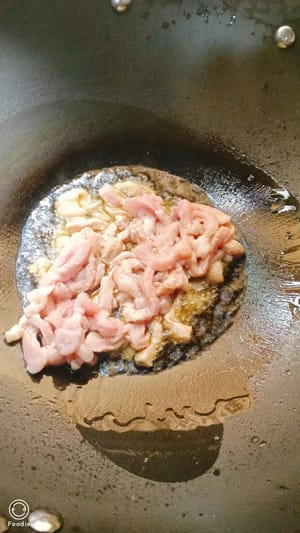 Pour oil into the pan, add the shredded pork and stir-fry quickly over high heat.