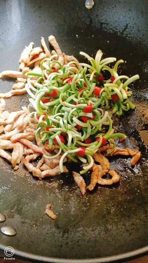 Add the garlic shoots and stir-fry over high heat for 1 to 2 minutes.
