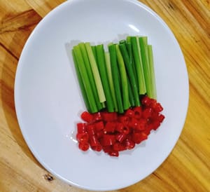 Cut garlic shoots into 4-5 cm segments and cut chili peppers into round shapes