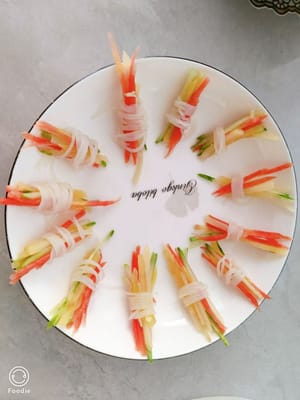 薯仔絲，黃瓜絲，胡蘿蔔絲，用泡粉絲一個一個的綁起嚟，像這樣把它擺成一個造型。