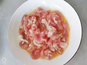 切好的肉裡放入鹽，生抽，蠔油，生粉，打入一個土雞蛋。戴上手套幫他抓勻。